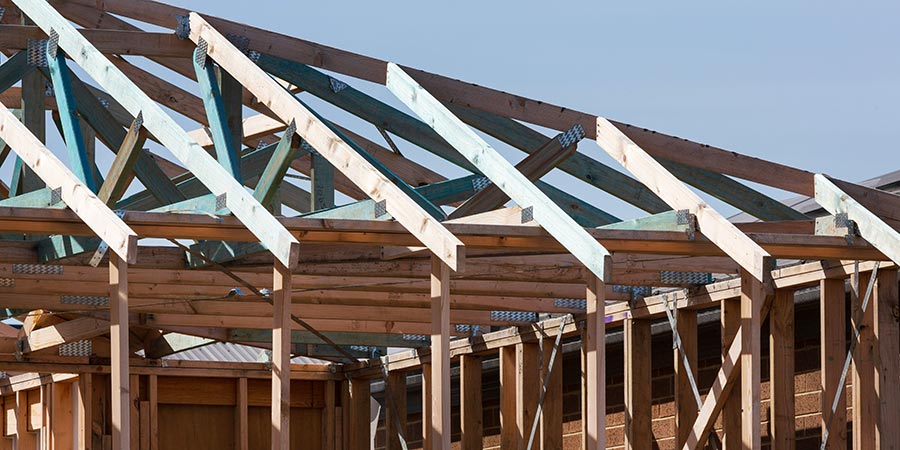 Wooden framing of a new residential building under clear blue sky